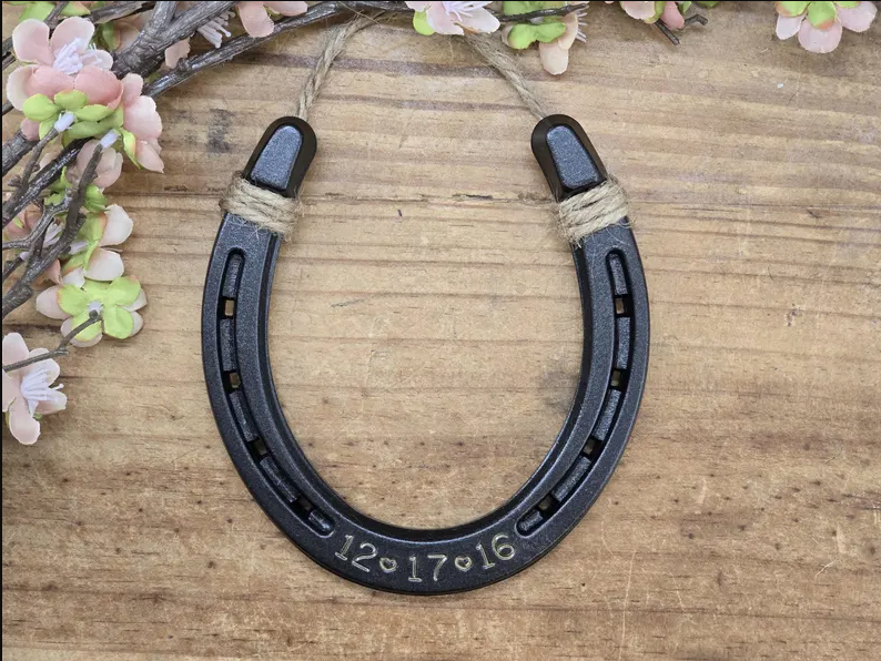Real horseshoe painted an oil-rubbed bronze color and engraved with a date. Jute string at the top for hanging.