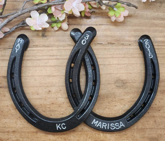 Authentic horseshoes painted an oil-rubbed bronze color and welded together. Stamped along the bottom with names and a date along the top. Made specifically for 8 year anniversaries.