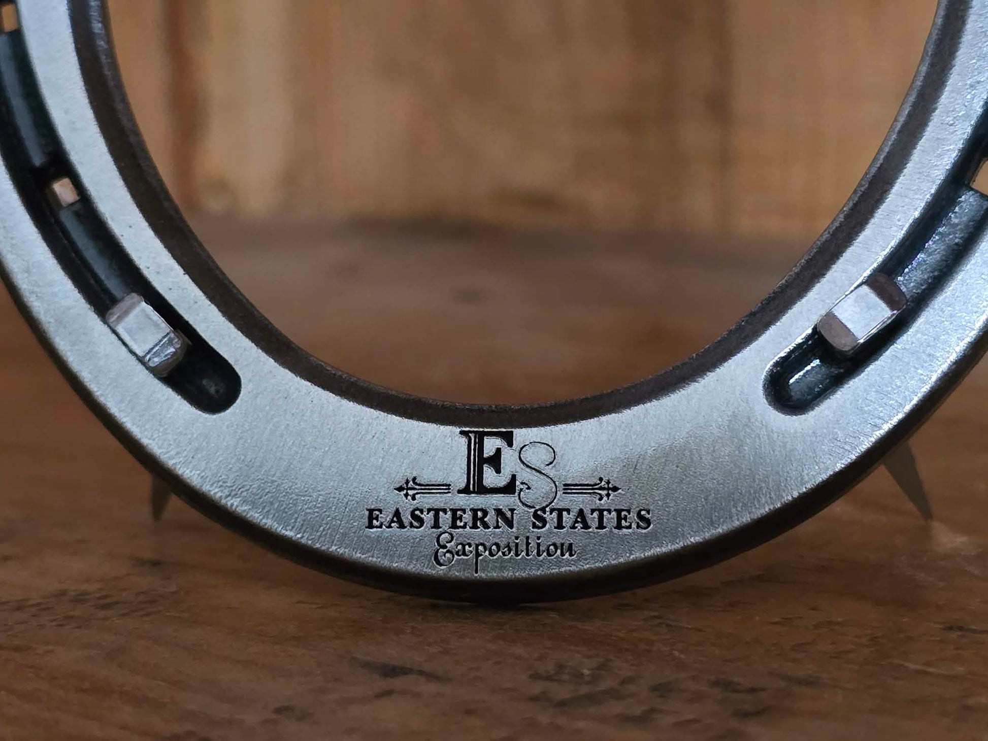 Real metal horseshoe engraved along the bottom with a logo of a company 