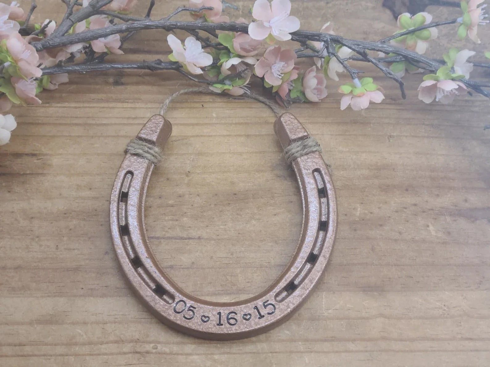 Real horseshoe engraved with a custom date along the bottom. Jute string at the top for hanging. Perfect 7 year copper anniversary gift.