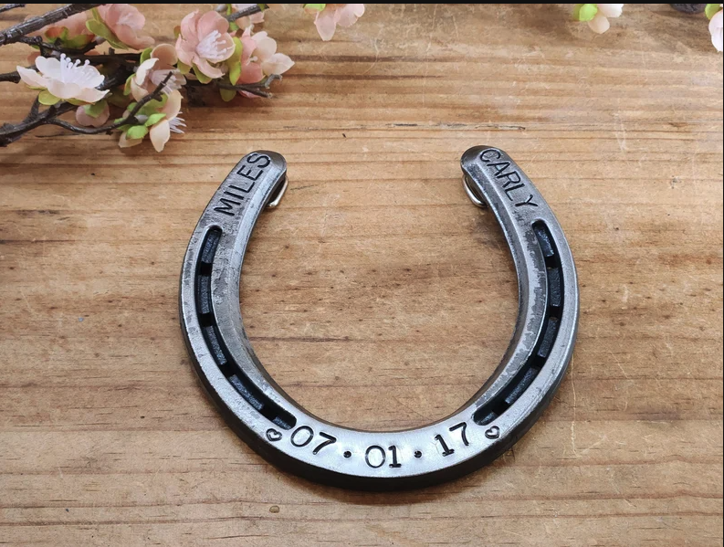 Real horseshoe personalized with two names and a date. Designed with hooks on the back for hanging.