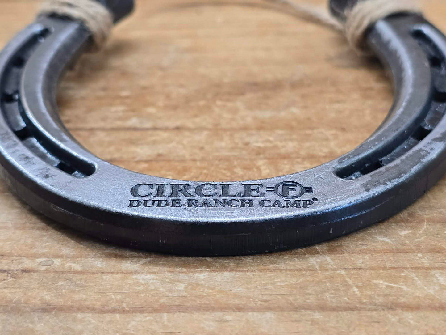 Real metal horseshoe engraved along the bottom with a logo from Circle F Dude Ranch Camp.