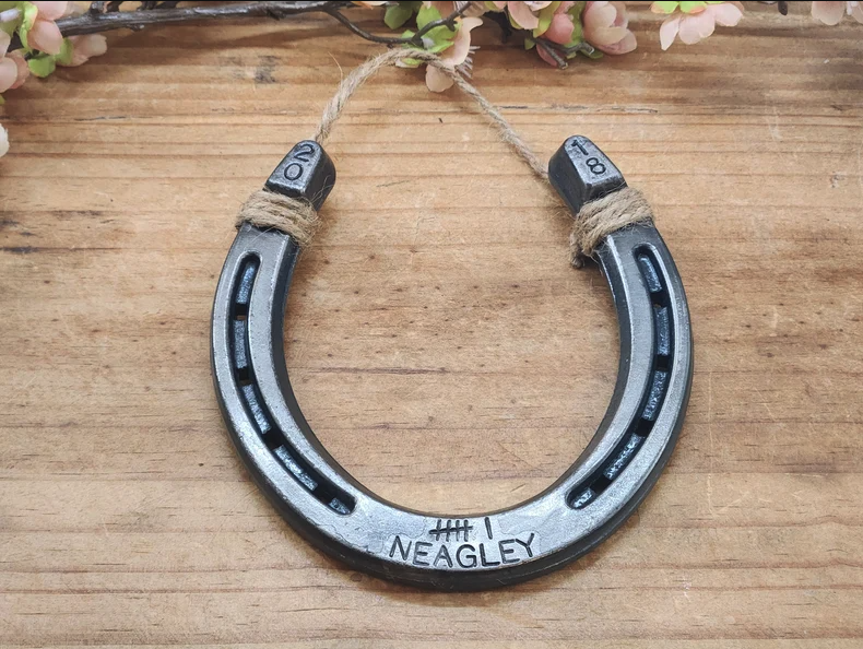 Unique handmade horseshoe decor with 6 tally marks and a last name stamped along the bottom and the anniversary year stamped in the upper corners.