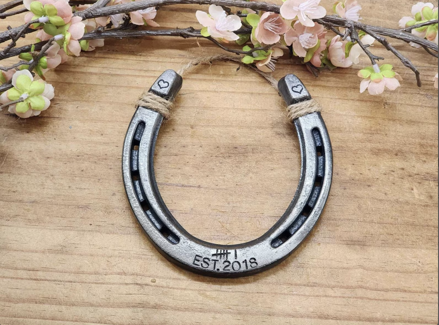 Real horseshoe stamped with 6 tally marks along the bottom and Est 2018 to represent 6 years. Hearts are stamped on the upper corners of the horseshoe. 