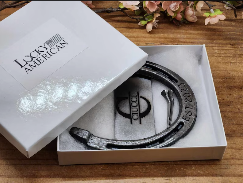 Real horseshoe with custom monogram in the center and the anniversary year engraved along the bottom of the horseshoe. Displayed in a gift box.