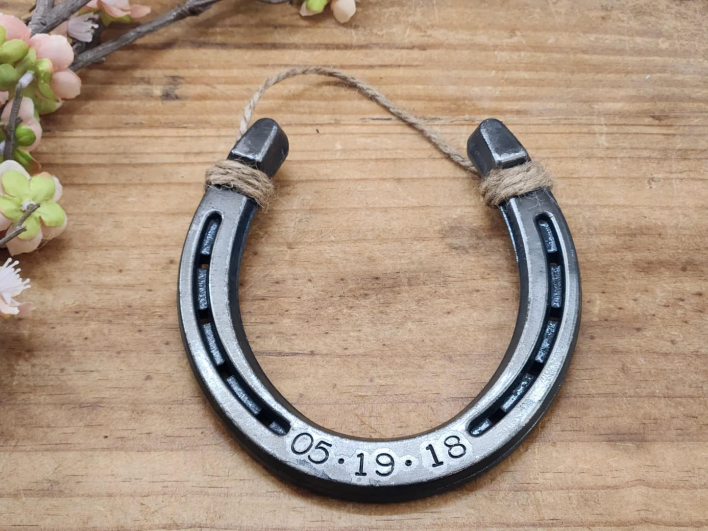 Real horseshoe engraved with anniversary date along the bottom. Jute string attached at the top for hanging.