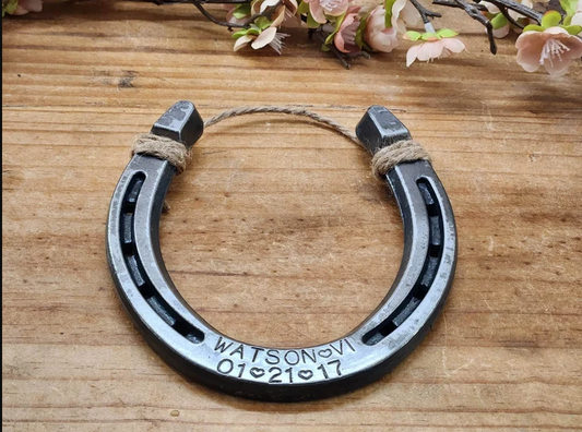 Authentic horseshoe keepsake with a last name and the Roman Numeral for "6" engraved along the bottom plus the anniversary date. Shown with jute string at the top for hanging.