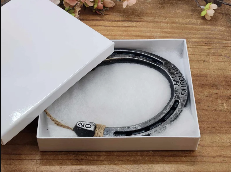 Unique handmade horseshoe decor with 6 tally marks and a last name stamped along the bottom and the anniversary year stamped in the upper corners. Displayed in gift box