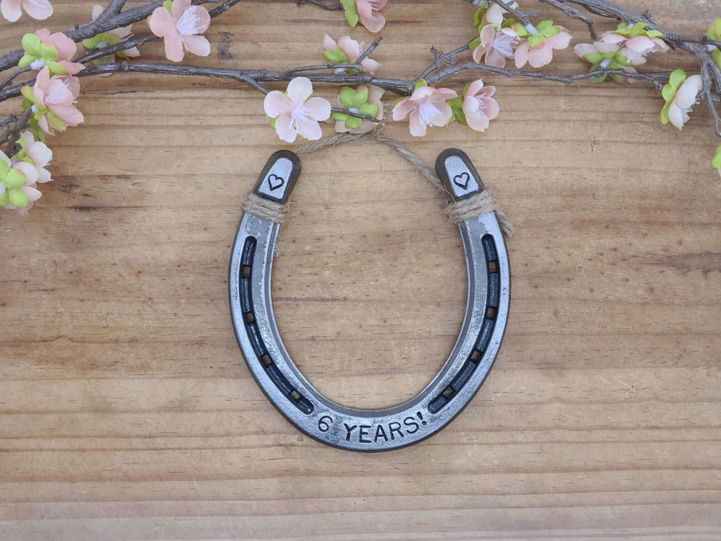 Real horseshoe with '6 YEARS!' stamped along the bottom and a heart stamped in each upper corner of the horseshoe.