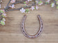 Real horseshoe painted copper to commemorate the 7 year copper anniversary. Personalized with names along the top and a date along the bottom.