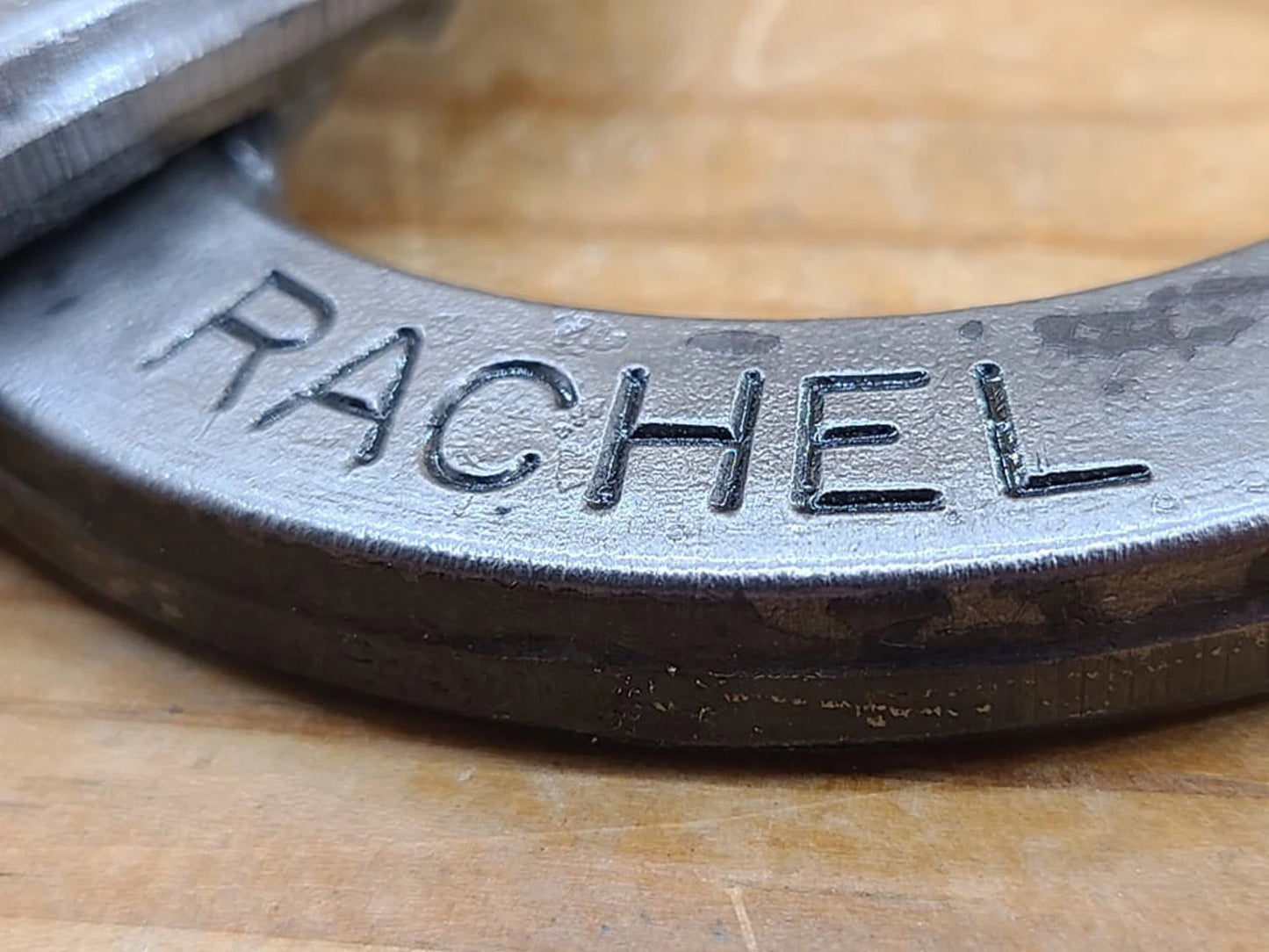 Detailed view up close of a real horseshoe with a name stamped along the bottom.