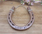 Real horseshoe spray painted copper with 'LUCKY #7' along the bottom and customized with the year in the upper corners. Designed to hang from jute string.