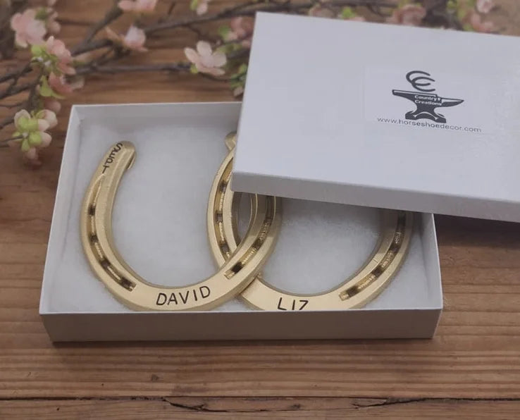 Real horseshoes painted gold and personalized with names and date. Displayed in a gift box.