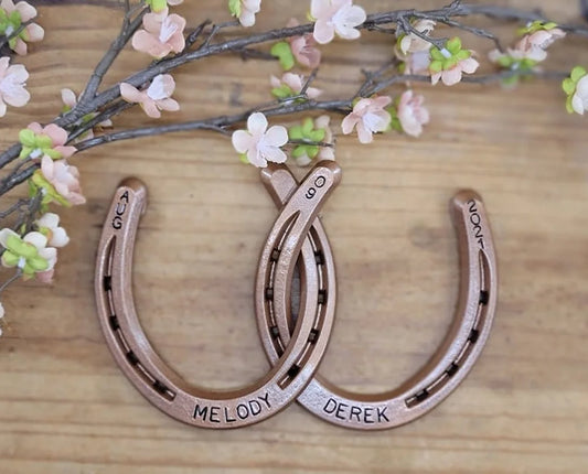 Real horseshoes painted copper to celebrate the 7 year anniversary. Personalized with names along the bottom and wedding date along the top.
